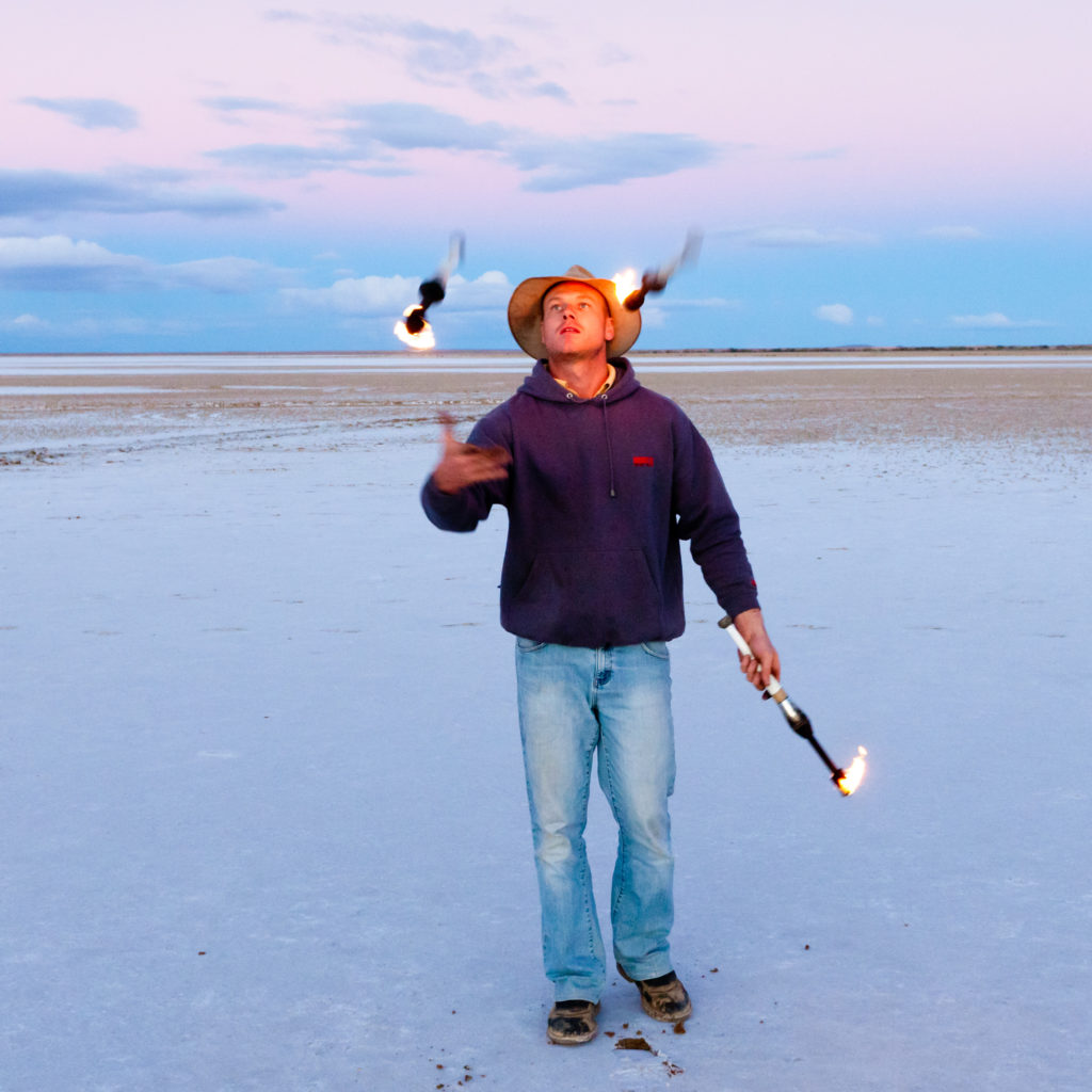 Juggler, Andrew Glegg juggling fire on a salt lake. Commercial Photography Mildura
